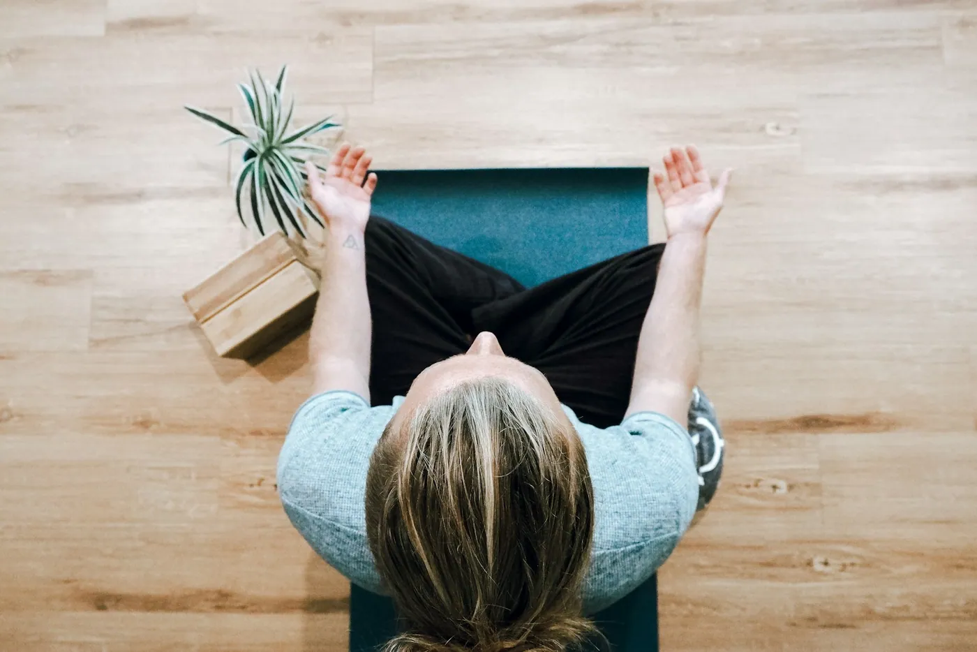 Mulher alongando-se sobre um tapete de yoga, vista de cima