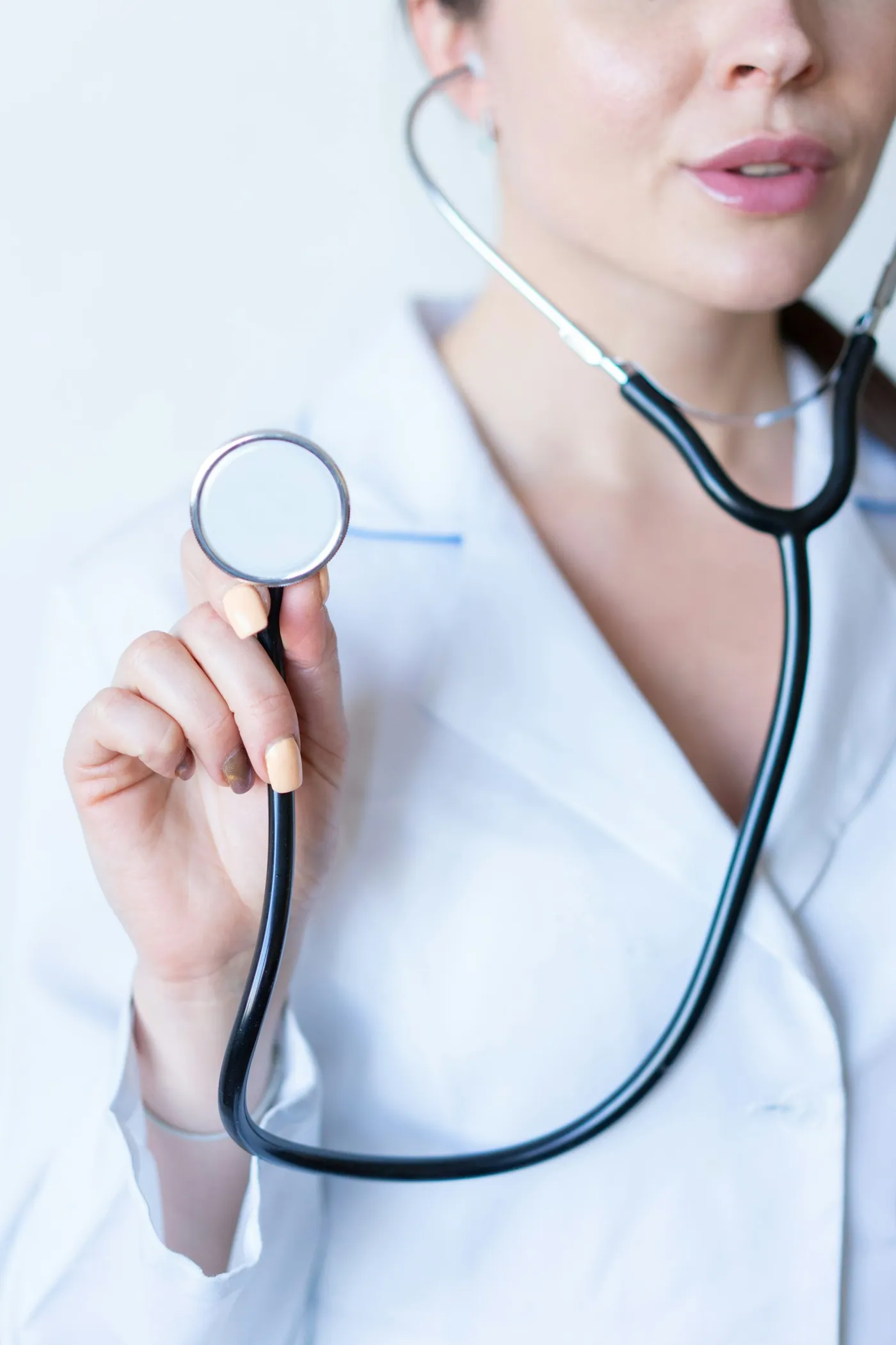 Médica segurando estetoscópio durante consulta